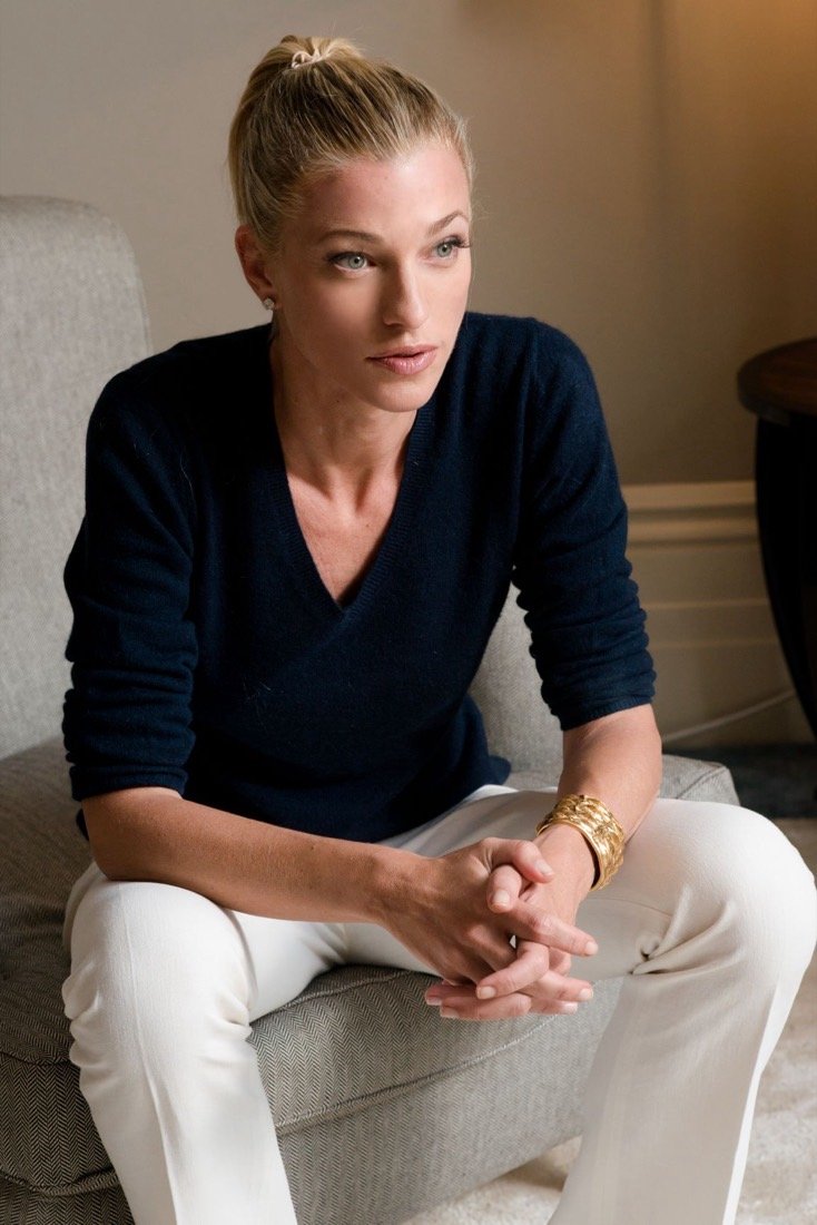 Nicole Junkerman reading in an armchair in warm, quiet light.