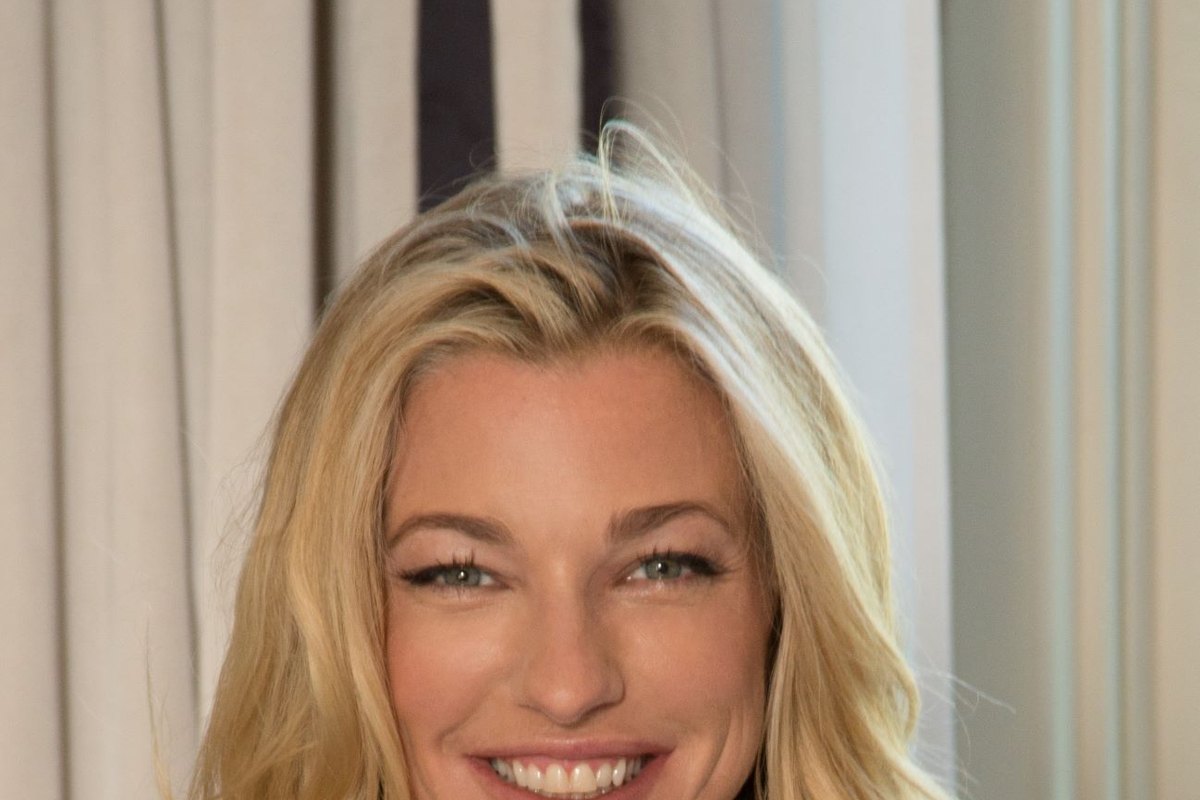 Warm, smiling portrait of Nicole Junkerman in a softly lit room.